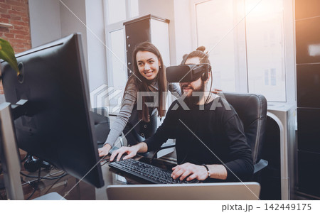 The young man with girlfriend plays a game at the office. The young man with girlfriend plays a game at the office. 142449175