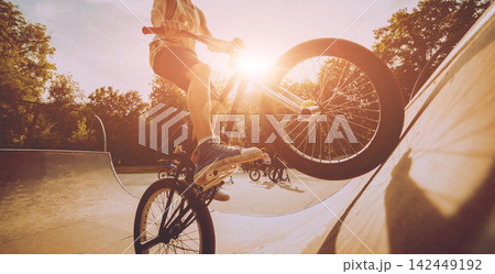 Boy riding a bmx in a park. Boy riding a bmx in a park. 142449192
