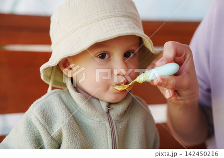 Cose-up of a Toddler Eating Baby Food from a Spoon Cose-up of a Toddler Eating Baby Food from a Spoon 142450216