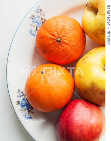 Group of colorful fresh fruits on table, ripe oranges citrus and apples on white background Group of colorful fresh fruits on table, ripe oranges citrus and apples on white background 142450916
