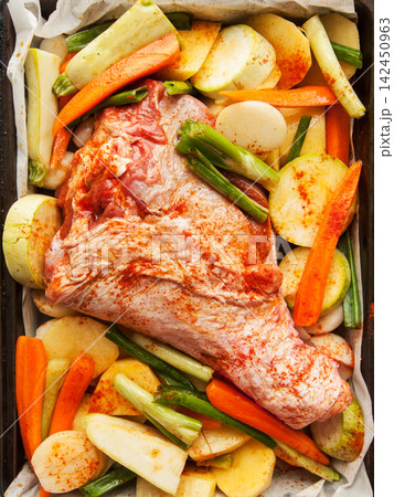 Fresh raw marinated turkey leg in baking pan with potatoes, carrots, onion and squash before oven 142450963