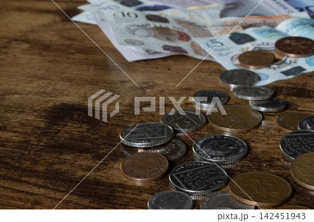 British coins and banknotes on wooden table 142451943