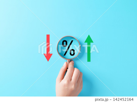 Interest rate increase and decrease concept. Magnifying glass over percentage symbol between red down and green up arrows representing finance analysis, rate change, inflation, loan cost, market trend Interest rate increase and decrease concept. Magnifying glass over percentage symbol between red down and green up arrows representing finance analysis, rate change, inflation, loan cost, market trend 142452164