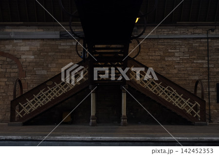 Railway station platform with pedestrian bridge stairs, architecture and stone wall in Perth, Scotland Railway station platform with pedestrian bridge stairs, architecture and stone wall in Perth, Scotland 142452353