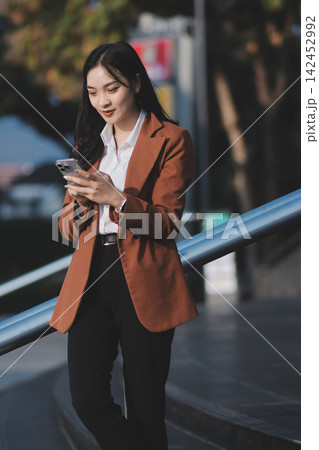 Young businesswoman smiling while working with digital tablet at modern office building Young businesswoman smiling while working with digital tablet at modern office building 142452992