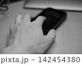スマートフォンを触る手 モノクロームのライフスタイル写真 142454380