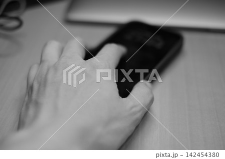 スマートフォンを触る手 モノクロームのライフスタイル写真 スマートフォンを触る手 モノクロームのライフスタイル写真 142454380