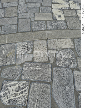 It is a neatly paved stone floor. 142454469
