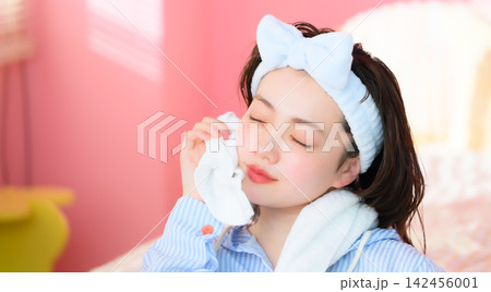 顔を拭く女性、スキンケアのイメージ 顔を拭く女性、スキンケアのイメージ 142456001