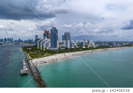 Aerial night view of Miami coastline. Twilight skyline above the Miami oceanfront. Miami Beach waterfront glowing after sunset. Aerial night view of Miami coastline. Twilight skyline above the Miami oceanfront. Miami Beach waterfront glowing after sunset. 142456538