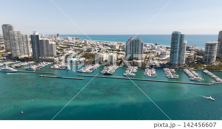 Yacht docked at Miami marina. Aerial view of coastline in Miami. Miami skyline above harbor. Famous Miami Beach marine from above. Marina with yachts. 142456607