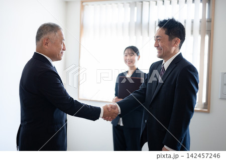 商談が成立し笑顔で握手を交わすビジネスパーソン 商談が成立し笑顔で握手を交わすビジネスパーソン 142457246