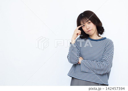 頭を抱えて悩んでいる女性 頭を抱えて悩んでいる女性 142457394