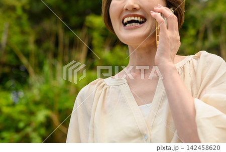 スマホで楽しそうに話す女性 142458620