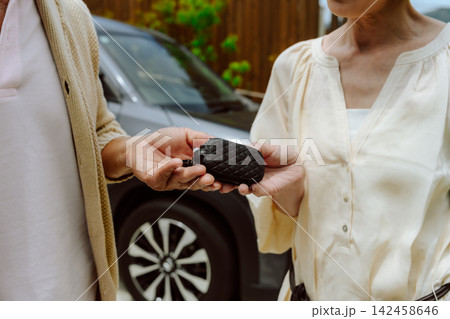 車の鍵を受け取るシニア夫婦 車の鍵を受け取るシニア夫婦 142458646