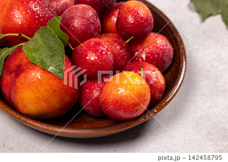 Fresh plums in bowl with water drops 142458795