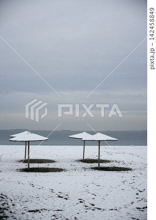 Beach straw umbrellas covered in snow Beach straw umbrellas covered in snow 142458849