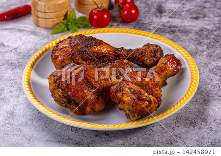 Roasted chicken drumsticks on yellow rimmed plate with cherry tomatoes and basil Roasted chicken drumsticks on yellow rimmed plate with cherry tomatoes and basil 142458971