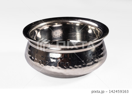 Handcrafted hammered metal bowl with reflective surface on white background Handcrafted hammered metal bowl with reflective surface on white background 142459163