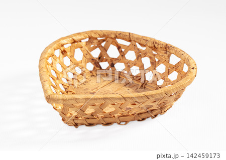 Handwoven wicker basket with open diamond pattern on white background Handwoven wicker basket with open diamond pattern on white background 142459173