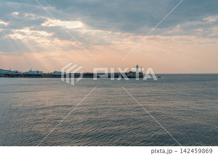 Sunset at the harbor with boats and lighthouse Sunset at the harbor with boats and lighthouse 142459869