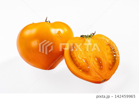 Golden tomato whole and halved on white background Golden tomato whole and halved on white background 142459965