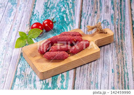 Mini salami on wooden board with cherry tomatoes and basil on rustic painted wood background Mini salami on wooden board with cherry tomatoes and basil on rustic painted wood background 142459990