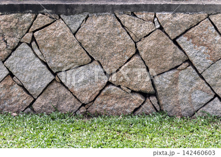 Close-up of a rustic granite stone wall with irregular fitted stones Close-up of a rustic granite stone wall with irregular fitted stones 142460603