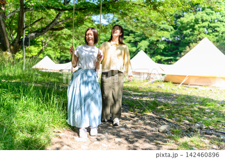 キャンプ場でブランコに乗る女性二人 キャンプ場でブランコに乗る女性二人 142460896