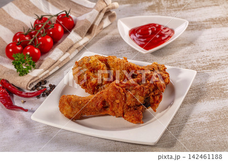 Crispy fried chicken legs on white plate with ketchup and cherry tomatoes Crispy fried chicken legs on white plate with ketchup and cherry tomatoes 142461188