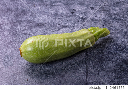 Fresh green zucchini on textured dark surface 142461333