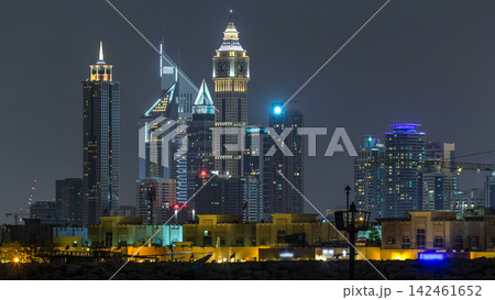 Modern Dubai city skyline timelapse at night with illuminated skyscrapers over water surface 142461652