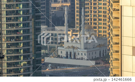 Al Raheem mosque between skyscrapers timelapse on the marina walk in Dubai Marina, Dubai, UAE. Al Raheem mosque between skyscrapers timelapse on the marina walk in Dubai Marina, Dubai, UAE. 142461666