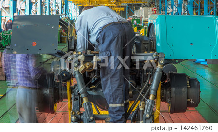 Conveyor assembly stage the body of tractor at big industrial factory timelapse Conveyor assembly stage the body of tractor at big industrial factory timelapse 142461760