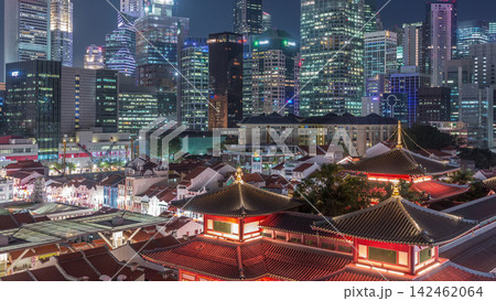 The Buddha Tooth Relic Temple comes alive at night in Singapore Chinatown day to night timelapse, with the city skyline in the background. The Buddha Tooth Relic Temple comes alive at night in Singapore Chinatown day to night timelapse, with the city skyline in the background. 142462064