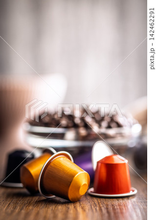 Colorful Coffee Capsules and Espresso Pods With Bowl of Roasted Coffee Beans on Wooden Table 142462291