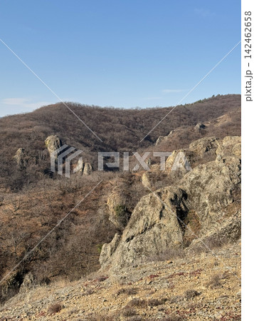 Rocky mountain slopes with bare forest under bright daylight sky. Rocky mountain slopes with bare forest under bright daylight sky. 142462658