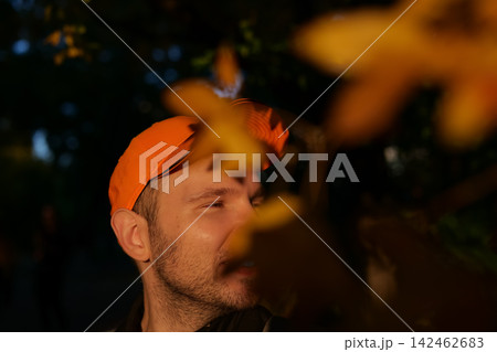 Man standing among autumn leaves illuminated by soft sunlight creating calm seasonal outdoor atmosphere. Man standing among autumn leaves illuminated by soft sunlight creating calm seasonal outdoor atmosphere. 142462683