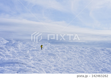 雪に覆われた山を歩く登山者と青空 雪に覆われた山を歩く登山者と青空 142463262