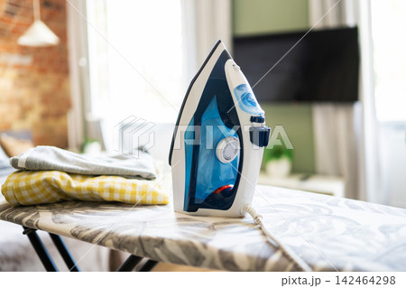 Iron On An Ironing Board In A Room 142464298