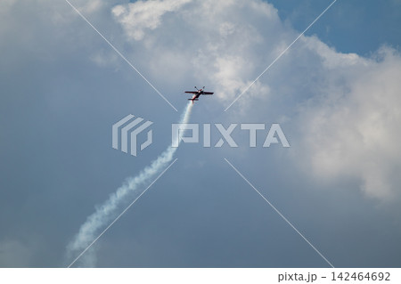 Stunt airplane ascends into cloudy sky 142464692