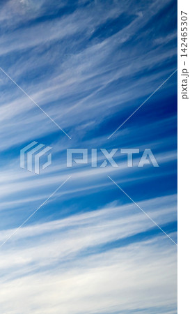 parallel stratus cloud bands cross the bright blue sky 142465307