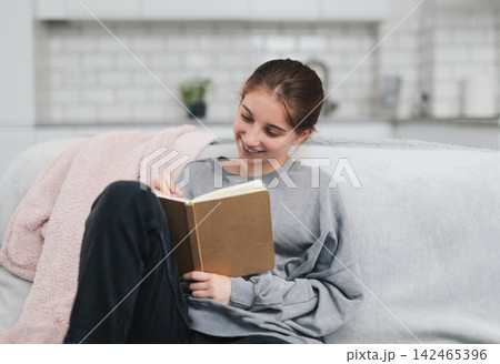 Pretty Girl Sitting On The Sofa At Home Writing Notes And Plans In A Notebook Pretty Girl Sitting On The Sofa At Home Writing Notes And Plans In A Notebook 142465396