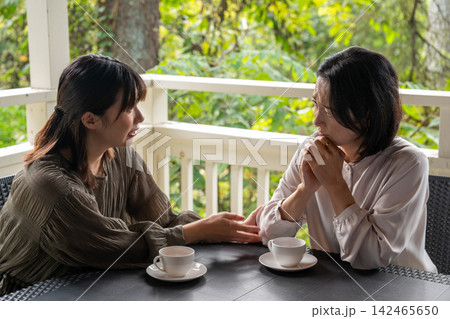 高原のカフェで友人を優しく慰める女性 142465650