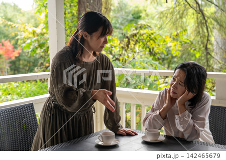 高原のカフェで悩みを打ち明ける女性と寄り添う友人 142465679
