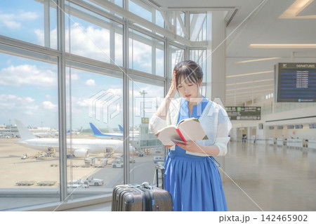 空港で本を見て頭を抱える女性 142465902