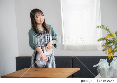 格子柄エプロン姿で微笑む女性 格子柄エプロン姿で微笑む女性 142465927