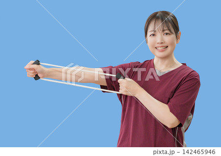 青背景でエクササイズ器具を使う女性 142465946