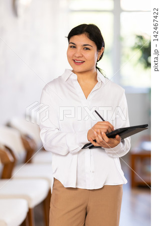 Portrait of friendly female receptionist with tablet Portrait of friendly female receptionist with tablet 142467422
