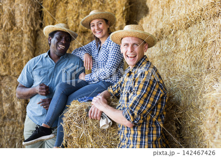 Group of farmers talking at hay storage 142467426